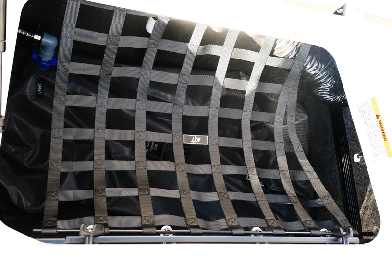 Slide: The Image of Storage compartment with netting in 2026 MasterCraft NXT23 boat. - 16
