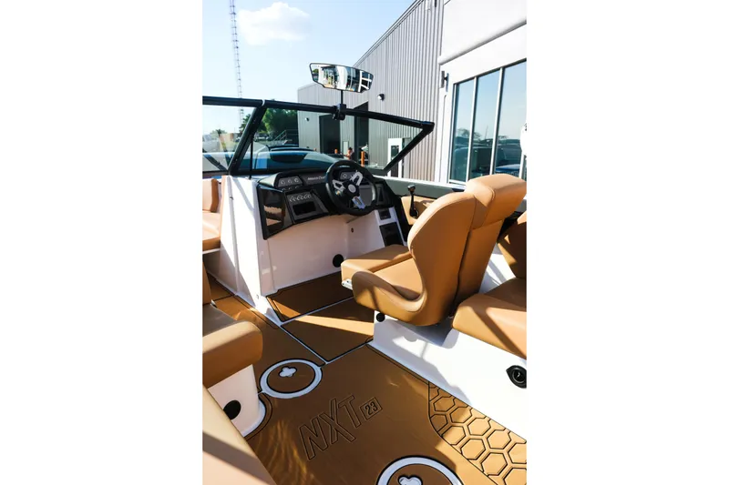 Slide: The Image of Interior of 2026 MasterCraft NXT23 boat with tan seating and modern dashboard. - 19