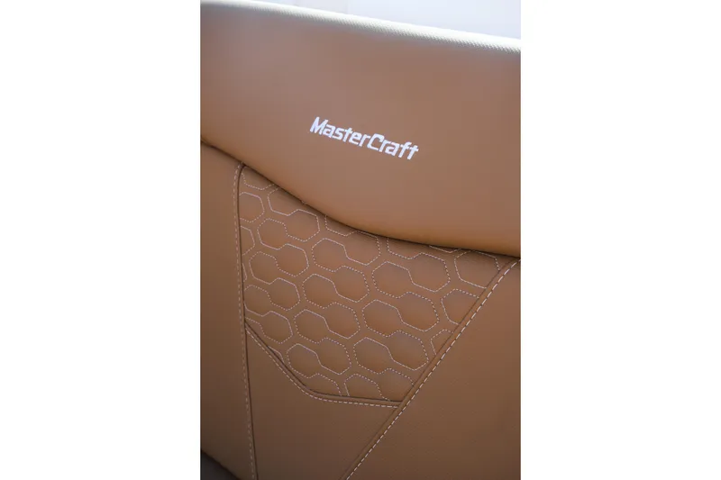 Slide: The Image of 2026 MasterCraft NXT23 boat seat with hexagonal stitching and logo detail. - 28