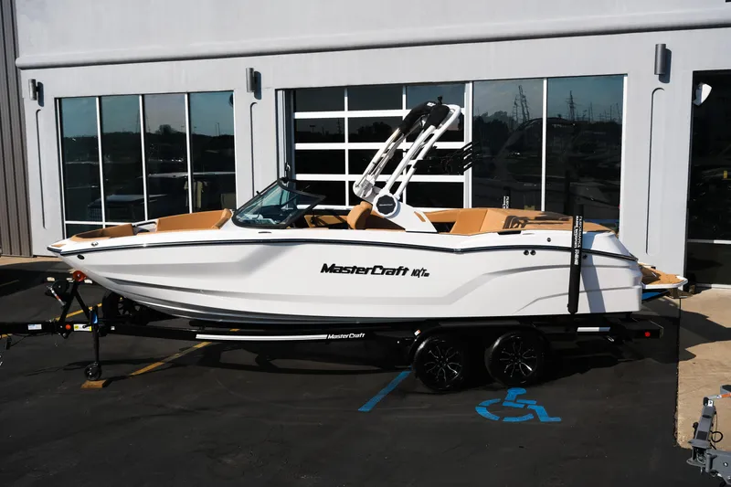 Slide: The Image of 2026 MasterCraft NXT23 boat on trailer, parked outside a building. - 3