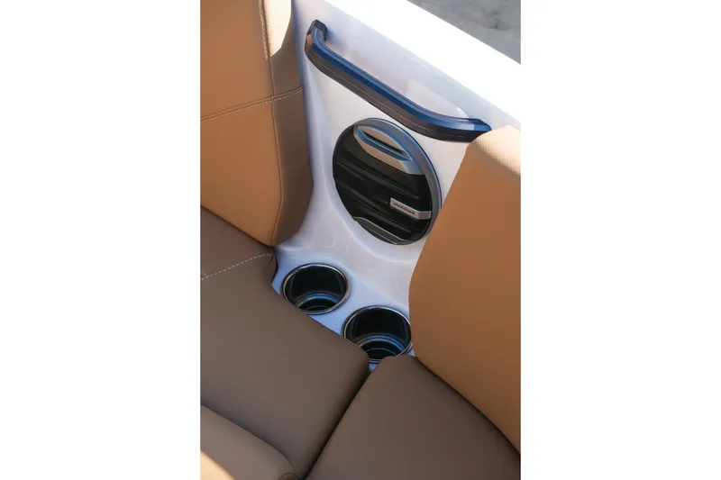Slide: The Image of 2026 MasterCraft NXT23 boat interior with brown seats, cup holders, and speaker. - 32