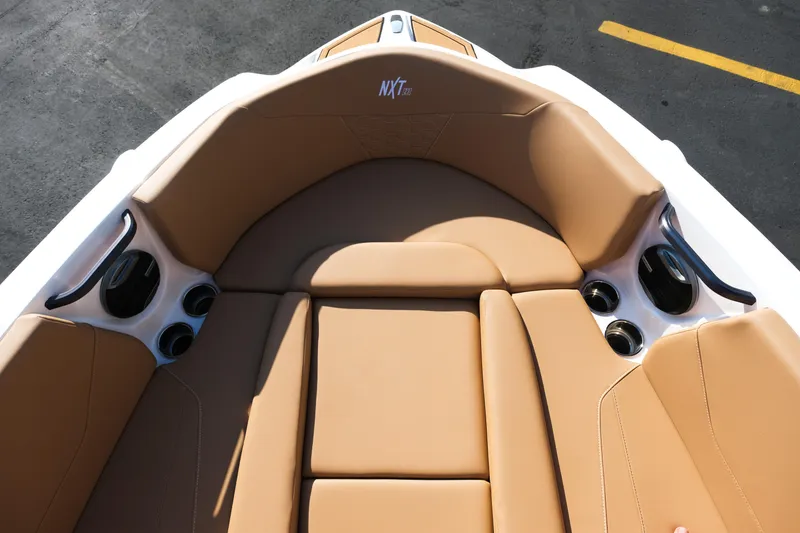 Slide: The Image of 2026 MasterCraft NXT23 boat interior with tan seating and cup holders. - 33