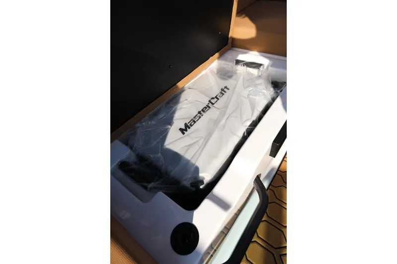 Slide: The Image of 2026 MasterCraft NXT23 boat interior with branded cover in storage compartment. - 35