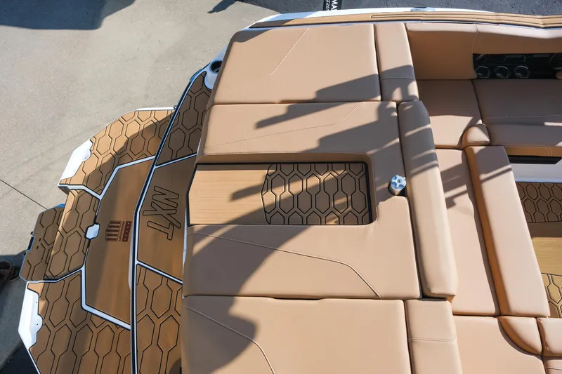 Slide: The Image of 2026 MasterCraft NXT23 boat interior with tan seating and hexagonal pattern flooring. - 37