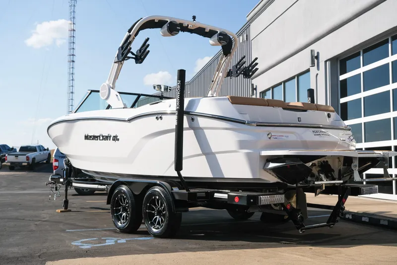 Slide: The Image of 2026 MasterCraft NXT23 boat on trailer, parked outdoors near a building. - 5