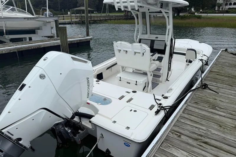 Slide: The Image of 2024 Tidewater 2500 Carolina Bay boat with open storage compartment on calm water. - 11