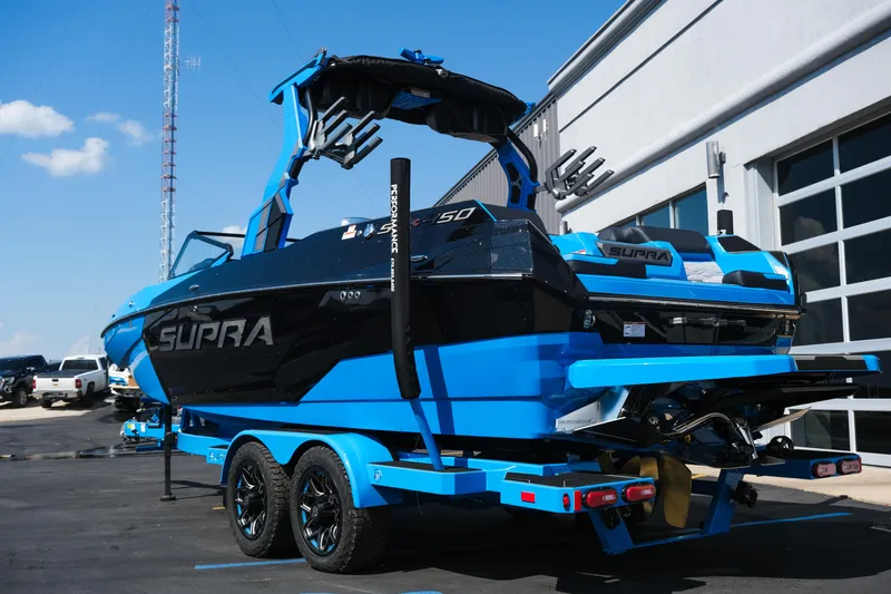 Slide: The Image of 2026 Supra SA450 boat in blue and black on a trailer, parked outdoors. - 4