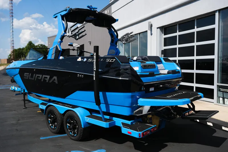Slide: The Image of 2026 Supra SA450 boat in blue and black, parked outside a modern building. - 40