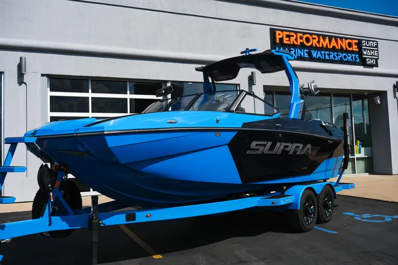 Slide: The Image of 2026 Supra SA450 boat in blue on trailer outside Performance Marine Watersports. - 44