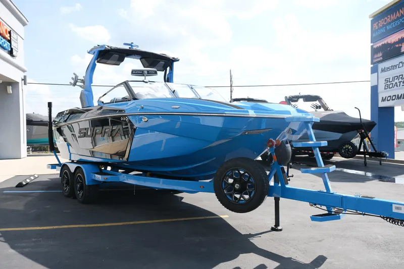 Slide: The Image of 2026 Supra SA450 boat in vibrant blue on a trailer at a dealership. - 46