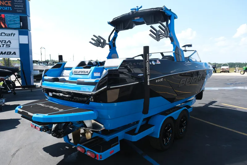 Slide: The Image of 2026 Supra SA450 boat in blue and black, displayed outdoors on a trailer. - 7