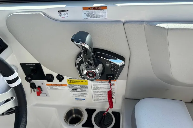 Slide: The Image of Control panel of 2026 Sea Ray SDX 230 Surf boat with throttle and warning labels. - 28