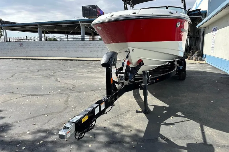 Slide: The Image of 2026 Sea Ray SDX 230 Surf boat on trailer, parked outdoors. - 4
