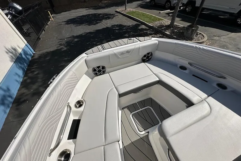 Slide: The Image of 2026 Sea Ray SDX 230 Surf boat interior with white seating and cup holders. - 40