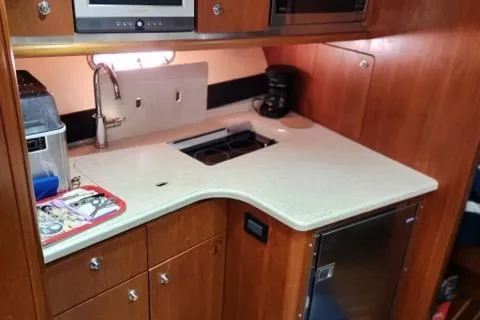 Slide: The Image of 2007 Tiara Yachts 3600 Open galley with sink, stove, and wooden cabinetry. - 40