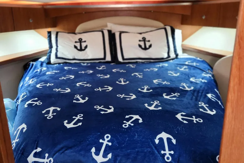 Slide: The Image of Nautical-themed bed in 2007 Tiara Yachts 3600 Open cabin, featuring anchor-patterned bedding. - 55