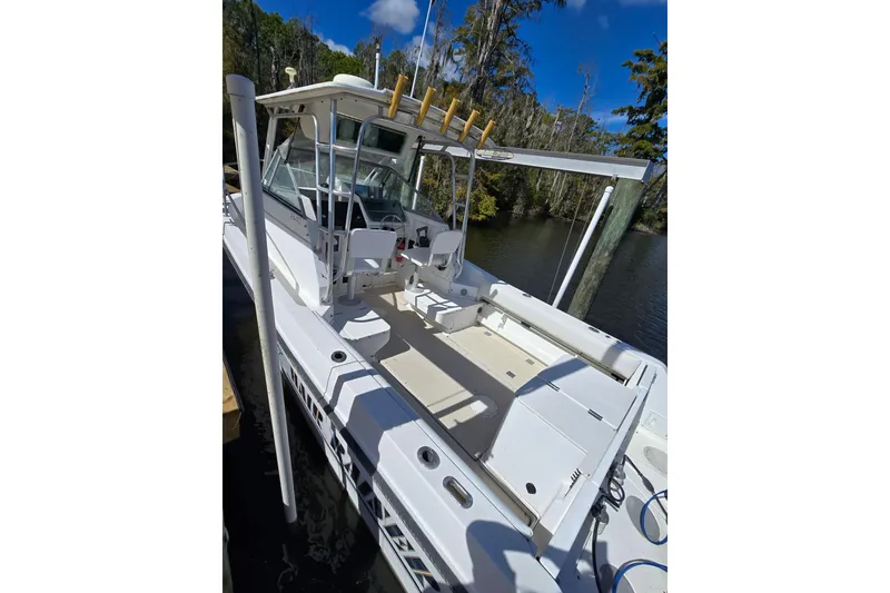 Slide: The Image of 1993 Robalo 2440 boat docked, featuring spacious deck and fishing rod holders. - 11