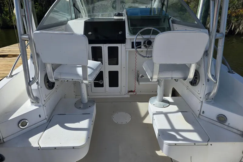 Slide: The Image of 1993 Robalo 2440 boat interior with dual captain chairs and steering wheel. - 12