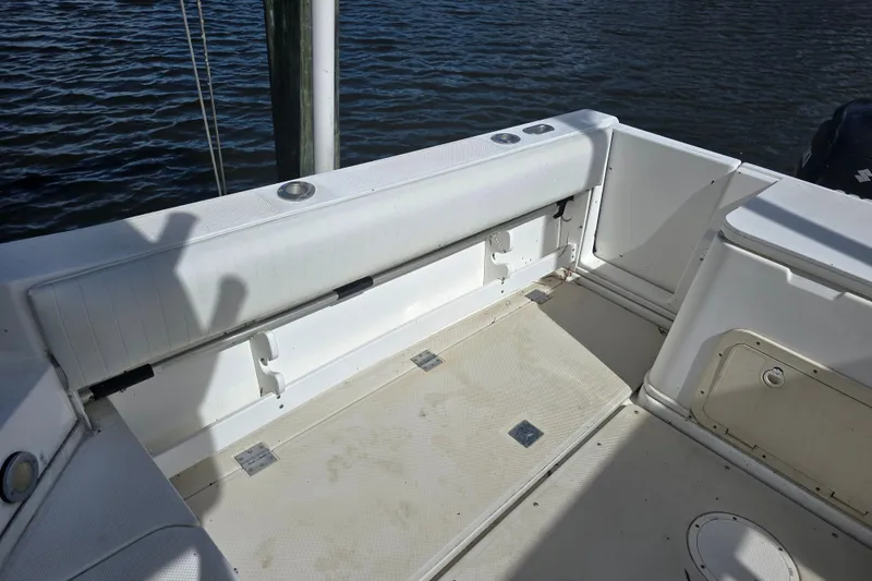Slide: The Image of 1993 Robalo 2440 boat interior with white seating and storage compartments. - 14
