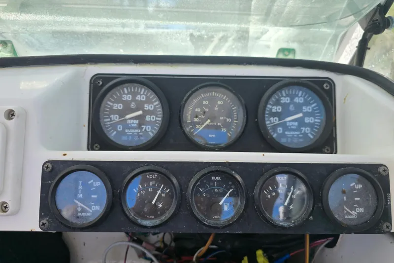 Slide: The Image of 1993 Robalo 2440 boat dashboard with gauges for RPM, speed, trim, fuel, and voltage. - 19