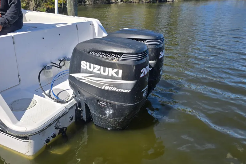 Slide: The Image of Twin Suzuki outboard motors on a 1993 Robalo 2440 boat in water. - 29
