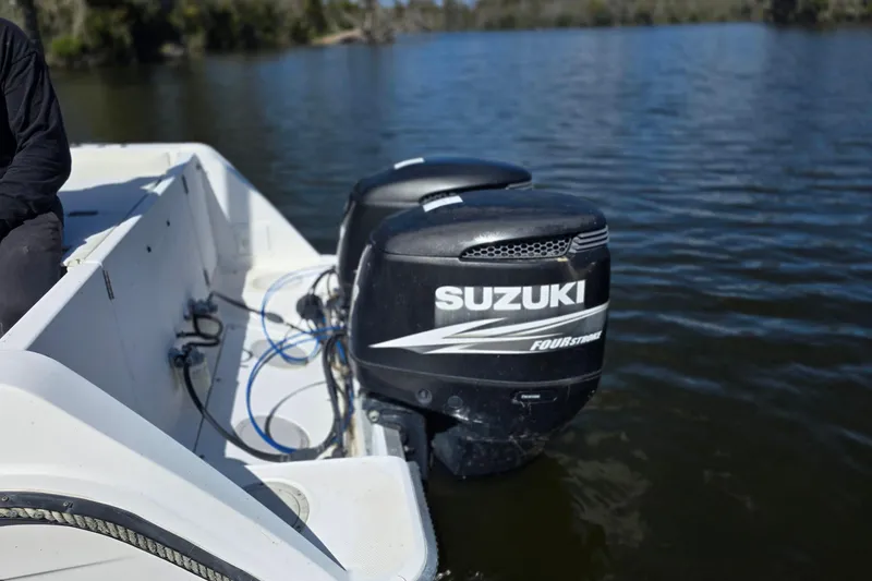 Slide: The Image of 1993 Robalo 2440 boat with Suzuki outboard engines on a calm lake. - 8