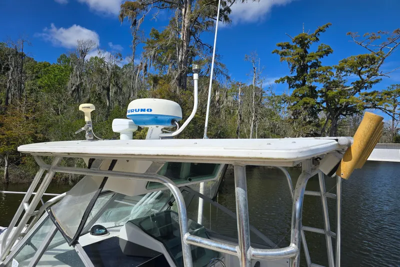 Slide: The Image of 1993 Robalo 2440 boat with radar equipment, docked in a scenic, wooded area. - 9