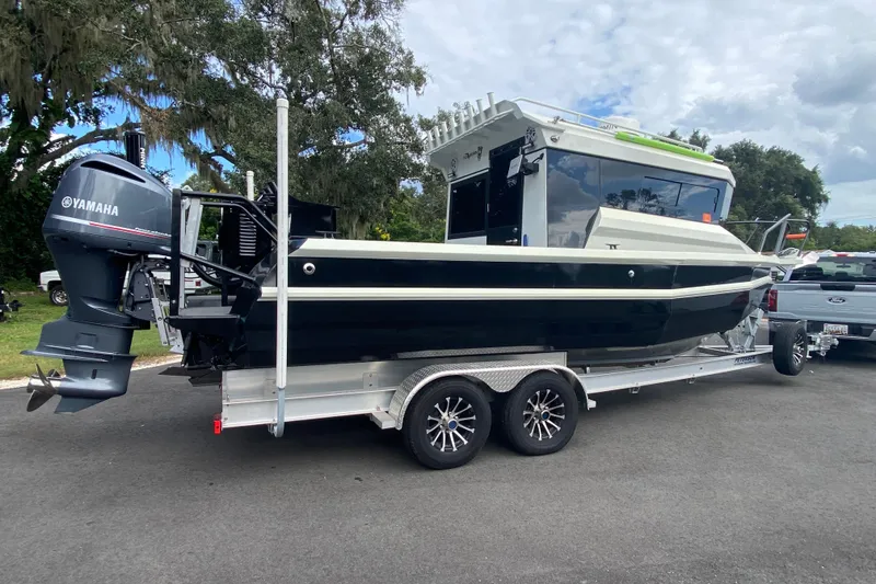 Slide: The Image of 2024 Sea King 260 boat on trailer with Yamaha outboard motor, parked outdoors. - 10