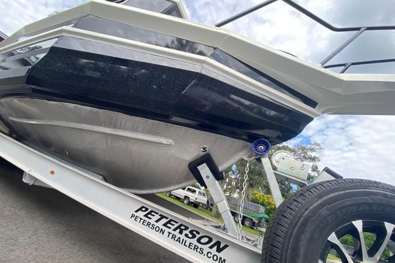 Slide: The Image of 2024 Sea King 260 boat on Peterson trailer, viewed from below, showcasing hull design. - 15