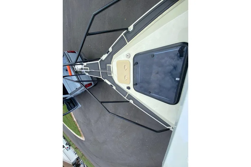 Slide: The Image of 2024 Sea King 260 boat bow with black railings and hatch, parked on pavement. - 18