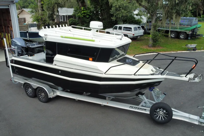 Slide: The Image of 2024 Sea King 260 boat on trailer, parked outdoors, showcasing sleek design and modern features. - 2