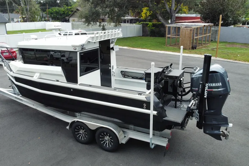 Slide: The Image of 2024 Sea King 260 boat on trailer with Yamaha outboard motor, parked on driveway. - 26
