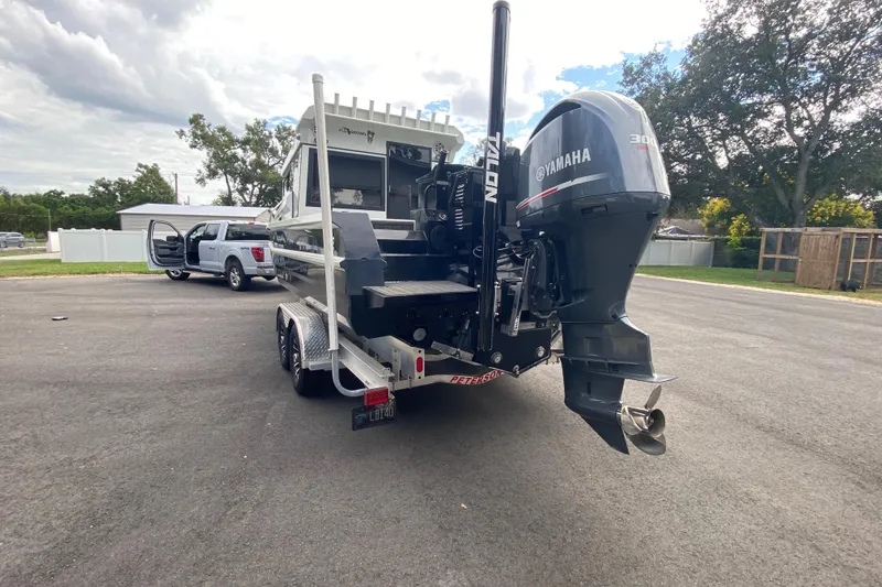 Slide: The Image of 2024 Sea King 260 boat with Yamaha motor on trailer, parked near a truck. - 32