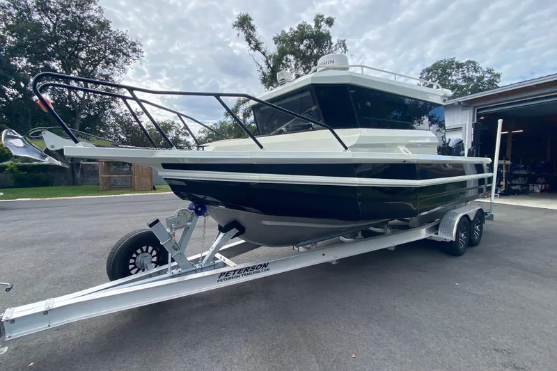 Slide: The Image of 2024 Sea King 260 boat on trailer, parked outdoors near a garage. - 8