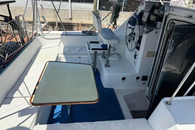 Slide: The Image of 1993 Jeanneau Lagoon 37 TPI Catamaran cockpit with seating, table, and steering wheel. - 4