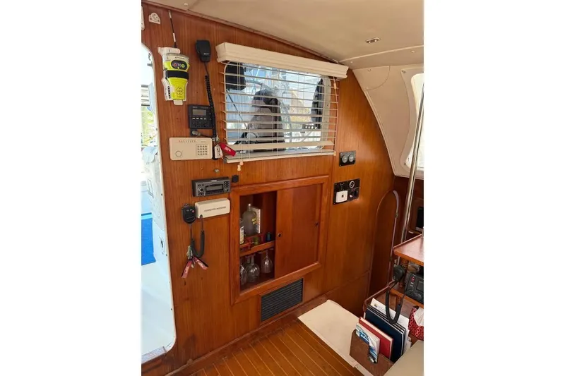 Slide: The Image of Interior of 1993 Jeanneau Lagoon 37 TPI Catamaran with wooden paneling and navigation equipment. - 5