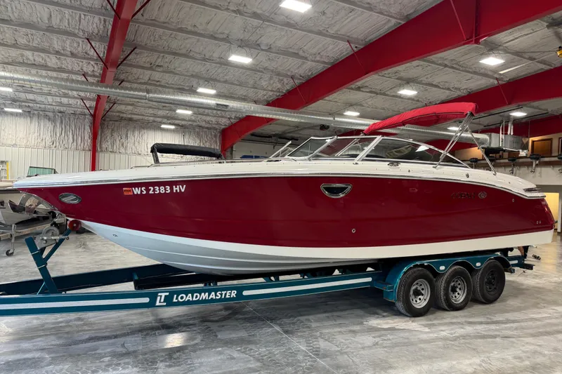 Slide: The Image of 2011 Cobalt 296 boat with red hull on Loadmaster trailer in indoor storage. - 2