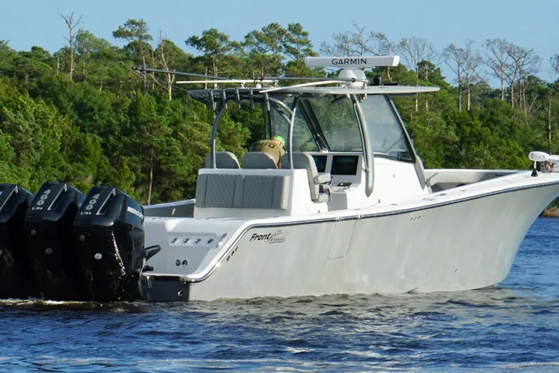 Slide: The Image of 2024 Front Runner 39 Center Console boat with multiple outboard engines on a scenic waterway. - 2