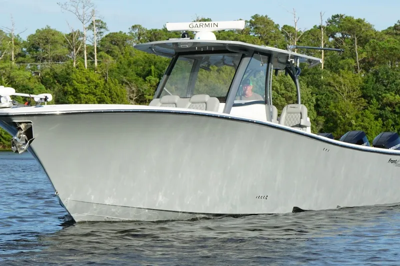 Slide: The Image of 2024 Front Runner 39 Center Console boat cruising on a calm lake with lush greenery. - 5