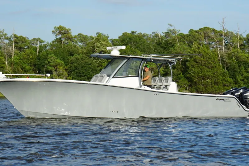 Slide: The Image of 2024 Front Runner 39 Center Console boat cruising on a scenic waterway. - 6