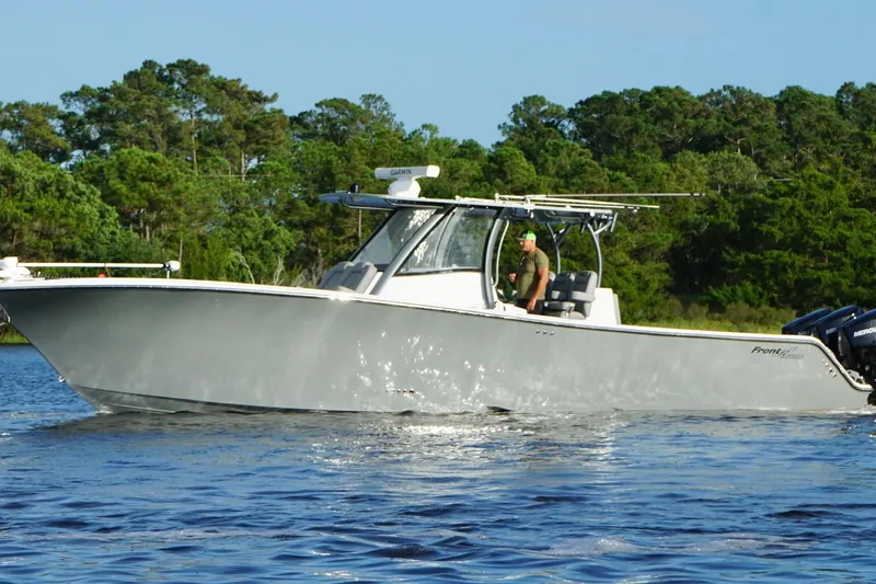 Slide: The Image of 2024 Front Runner 39 Center Console boat cruising on a serene lake with lush greenery. - 8
