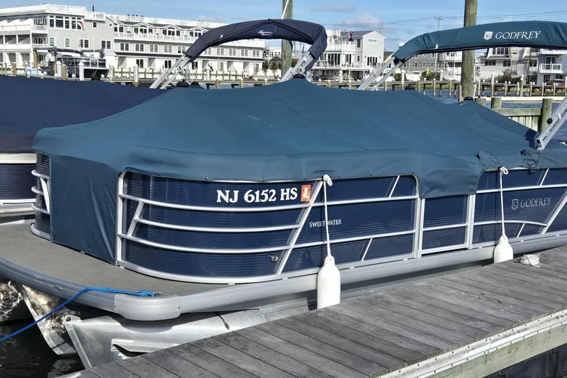 The Image of 2023 Godfrey Sweetwater 2286 SBX pontoon boat docked with blue cover. - 0