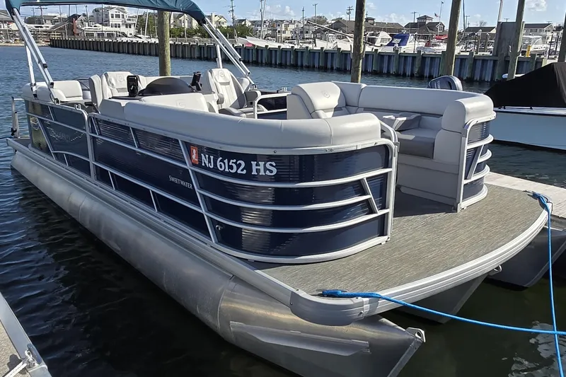 Slide: The Image of 2023 Godfrey Sweetwater 2286 SBX pontoon boat docked by the water. - 14