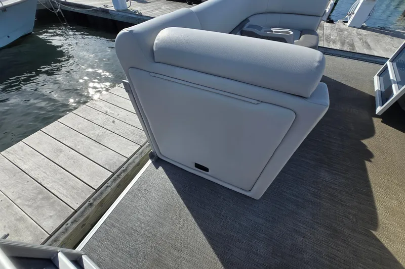 Slide: The Image of 2023 Godfrey Sweetwater 2286 SBX boat interior with seating and control panel at dock. - 20