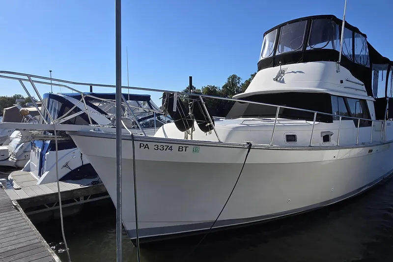 The Image of 1988 Mainship 36 Double Cabin yacht docked at marina under clear blue sky. - 0