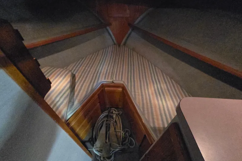 Slide: The Image of 1988 Mainship 36 Double Cabin interior with striped bedding and wooden accents. - 12