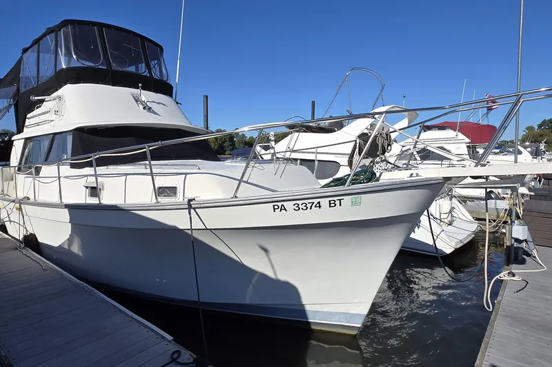 Slide: The Image of 1988 Mainship 36 Double Cabin yacht docked at marina under clear blue sky. - 16