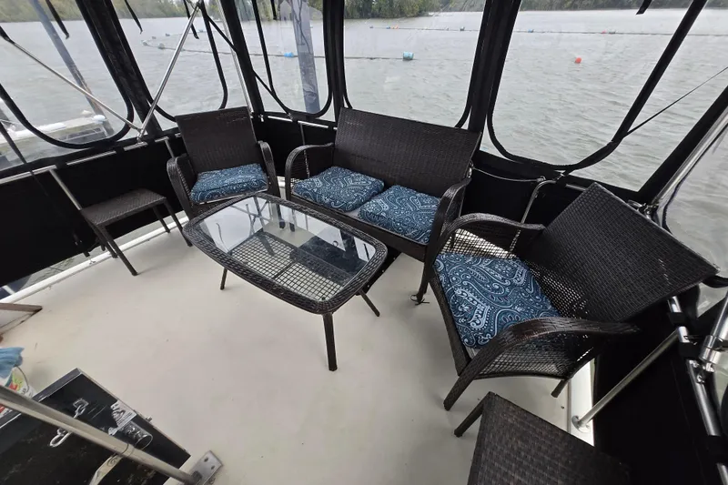 Slide: The Image of 1988 Mainship 36 Double Cabin with wicker seating and glass table on deck. - 17