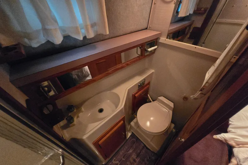 Slide: The Image of 1988 Mainship 36 Double Cabin bathroom with sink, toilet, and mirror. - 22