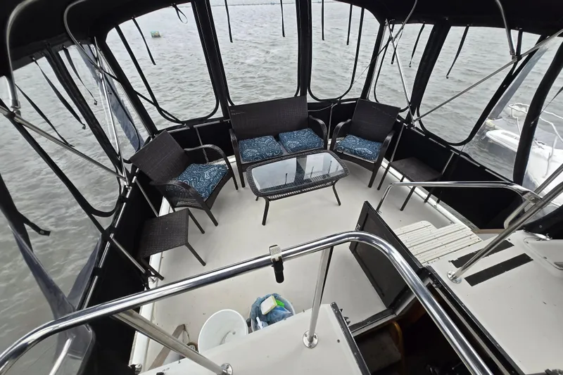 Slide: The Image of 1988 Mainship 36 Double Cabin boat interior with seating and table, overlooking water. - 24